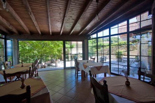 布埃乌托雷城乡村民宿的餐厅设有桌椅和大窗户。