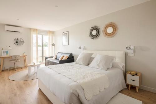 科洛米耶Studio Confort O NICO-Dormiratoulouse Colomiers的白色卧室配有一张大床和椅子