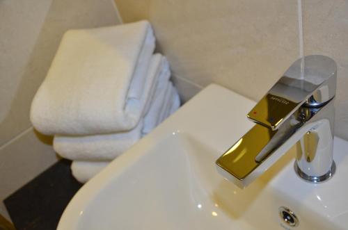 古来SEM9 Senai "Formerly Known As Perth Hotel"的一间带金色水龙头水槽的浴室