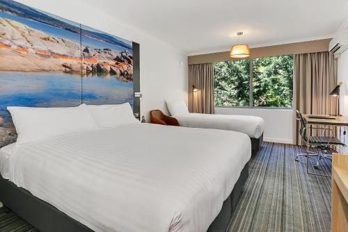 朗塞斯顿廊奇思通美居酒店的酒店客房设有两张床和大窗户。