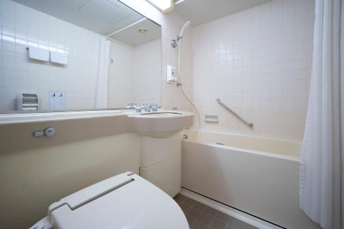 桑名市Kuwana Green Hotel的白色的浴室设有卫生间和水槽。