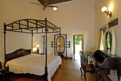 提喀迪Lake Palace的一间卧室配有天蓬床和桌椅