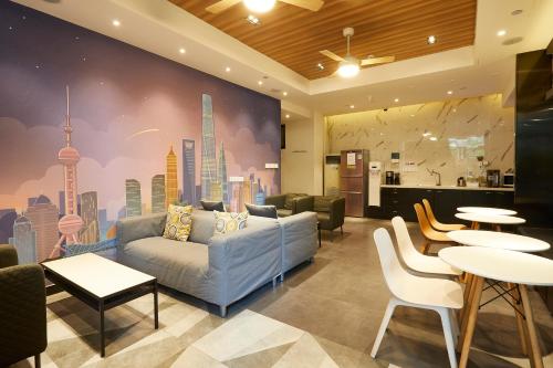 上海上海meego米果悦思酒店的客厅配有沙发和桌子,拥有城市壁画