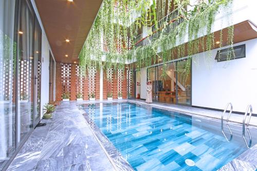 会安MaiChi Villa Hoi An的一座带大窗户的建筑中的游泳池