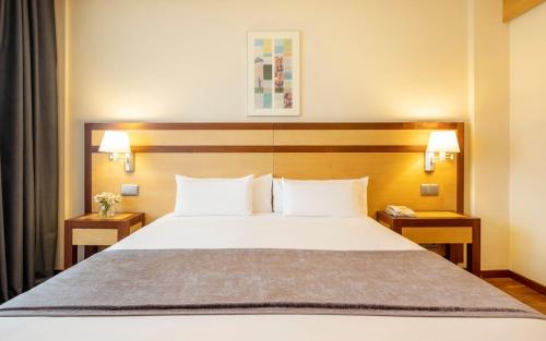 马德里伊鲁尼皮奥12号酒店的一间卧室配有一张带2个床头柜的大床