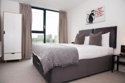 利物浦Open Key Apartments的一间卧室设有一张大床和一个大窗户