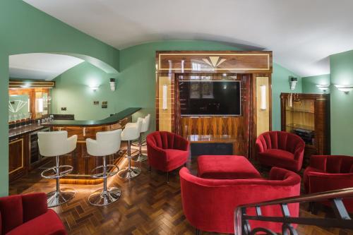 布莱顿霍夫Sea-facing Art Deco Apartment的一间带红色椅子的客厅和一间酒吧