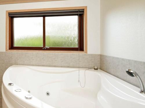 瓦伊厄斯斯特兰德8 person holiday home in Vejers Strand的带窗户的浴室内的白色浴缸