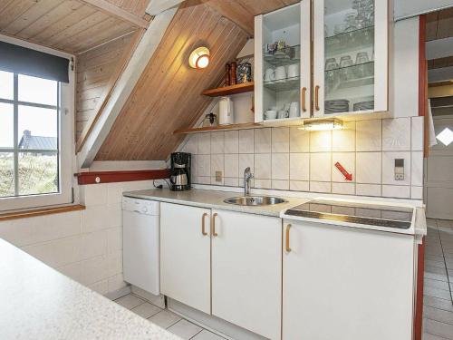 克莱戈德6 person holiday home in Ringk bing的厨房配有白色橱柜和水槽