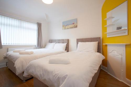 利兹Spacious Stylish Residence的配有白色床单的客房内的两张床