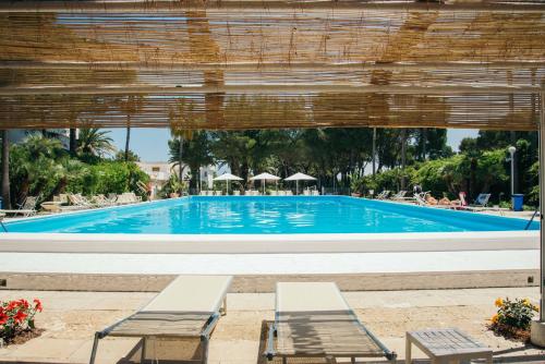 焦维纳佐里瓦德尔索尔酒店的前面设有2个长椅的大型游泳池