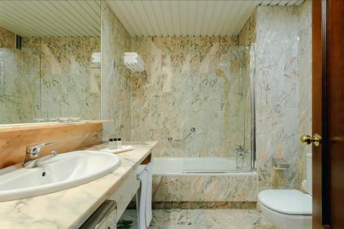 维戈赫斯珀里亚维戈酒店的一间带水槽、浴缸和卫生间的浴室