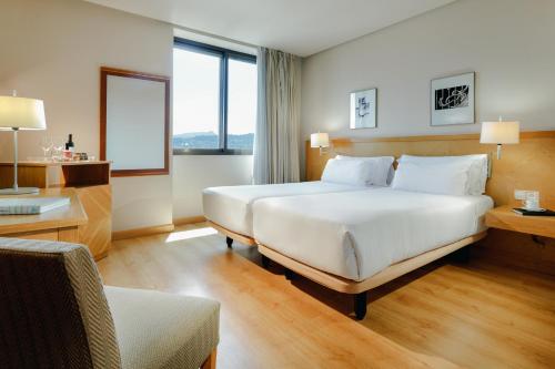 维戈赫斯珀里亚维戈酒店的酒店客房设有一张大床和一张书桌。