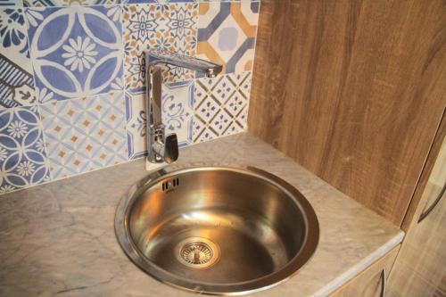 海塞卜Esra Hotel Apartment的厨房水槽和柜台上的水龙头