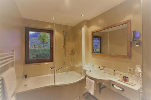 圣安东阿尔贝格蒙大拿酒店的带浴缸、水槽和镜子的浴室