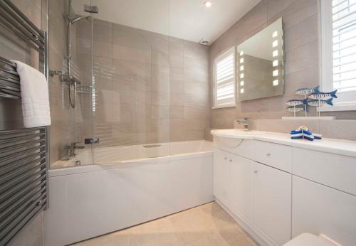 马根波思玛甘波思公寓的白色的浴室设有浴缸和水槽。