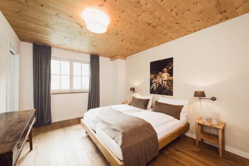格罗萨尔Chalet Stolz的一间卧室设有一张大床和木制天花板
