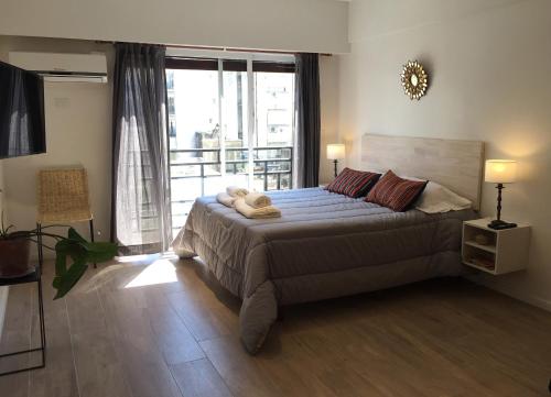 布宜诺斯艾利斯Moderno apartamento en excelente ubicación的一间卧室设有一张大床和大窗户