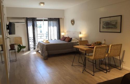 布宜诺斯艾利斯Moderno apartamento en excelente ubicación的一间卧室配有一张床铺和一张桌子,还有一间用餐室