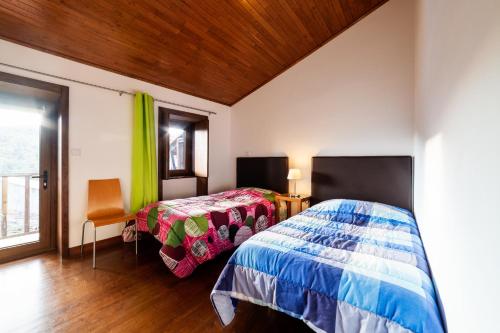 维尼艾什Casa da Mencha的一间卧室设有两张床和窗户。