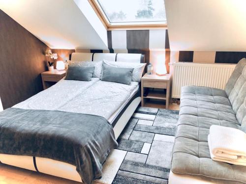 胡根尔舍姆Baden Airpark Family Apartment的一间卧室配有一张床和一张沙发