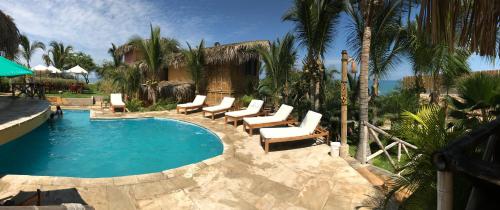 维加伊托El Mirador de Vichayito的一个带躺椅的游泳池,一个度假村
