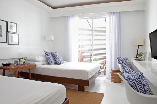 长滩岛蓝长滩岛码头酒店的一间卧室配有两张床、一张桌子和一台电视。