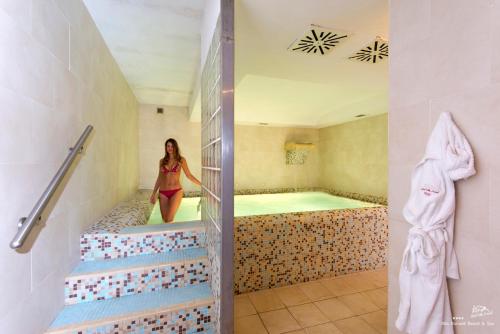 伊斯基亚Hotel Villa Durrueli Resort & Spa的女人站在浴室的浴缸里