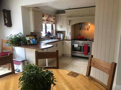 都柏林Beechtree House的厨房配有白色橱柜和带桌子的木桌。