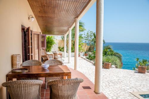 拉贡鹈鹕别墅 的一个带桌椅的庭院和大海
