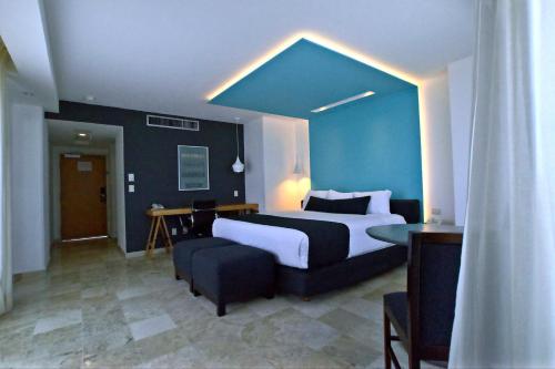 韦拉克鲁斯里沃利斯尔德酒店的一间卧室设有一张大床和蓝色的墙壁