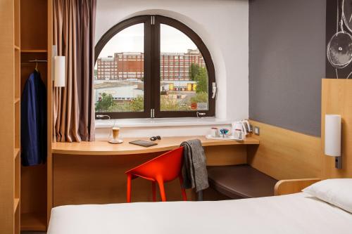 南安普敦宜必思南安普敦酒店的客房设有书桌、床和窗户。