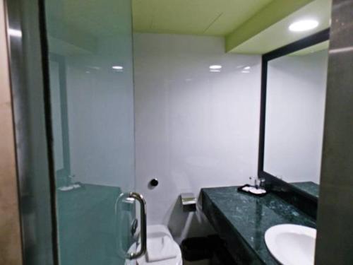 古晋港景酒店的一间带水槽、镜子和卫生间的浴室