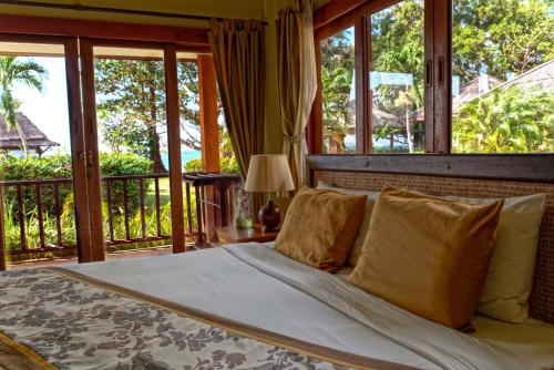 利巴诺伊Anahata Resort的一间卧室设有一张带窗户的床和一个阳台