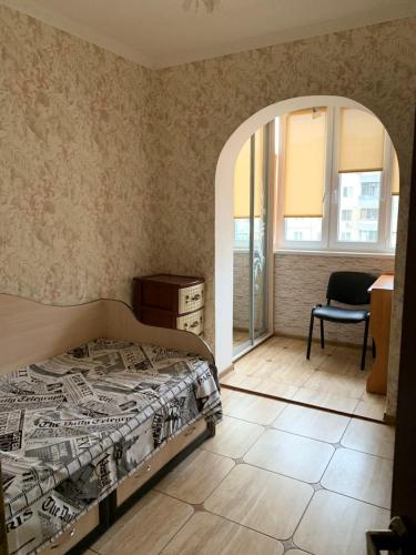 敖德萨131 проспект Добровольского Хорошая 3-х комнатная квартира в Одессе的卧室配有床、椅子和窗户。