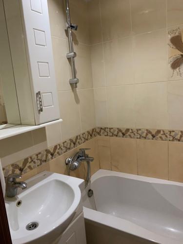 敖德萨131 проспект Добровольского Хорошая 3-х комнатная квартира в Одессе的浴室配有盥洗盆和浴缸。