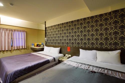 高雄华宾旅馆 的酒店客房带两张床和一面墙