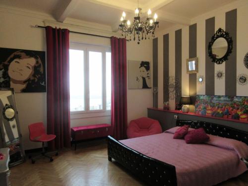 热那亚Doria House 23的一间卧室设有一张床、一个窗户和一个吊灯。