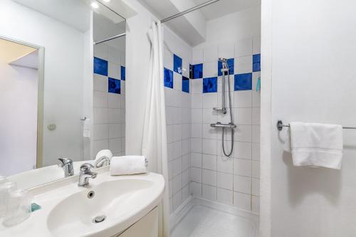托农莱班Appart'City Classic Thonon Les Bains的带淋浴和盥洗盆的白色浴室