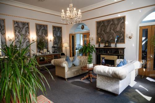 伯恩茅斯Derby Manor的带沙发和吊灯的客厅