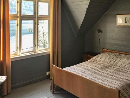 厄于斯特瑟Holiday home øystese的一间卧室设有一张床和两个窗户。