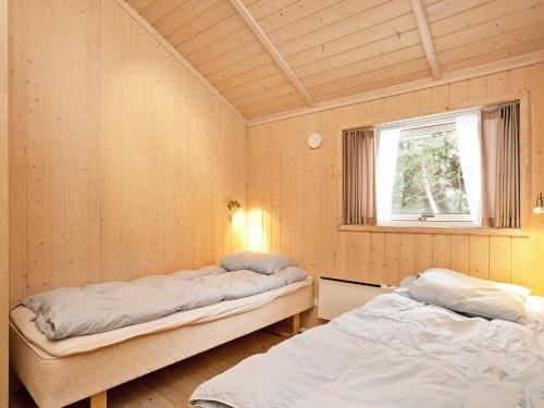 克兰尼茨Three-Bedroom Holiday home in Rødby 6的客房设有两张床和窗户。