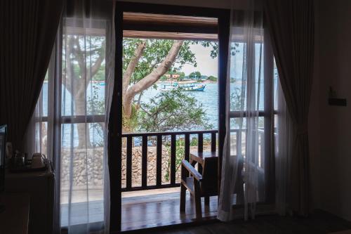 沙美岛The C Samet Beach Resort SHA Plus的通往享有水景的阳台的门