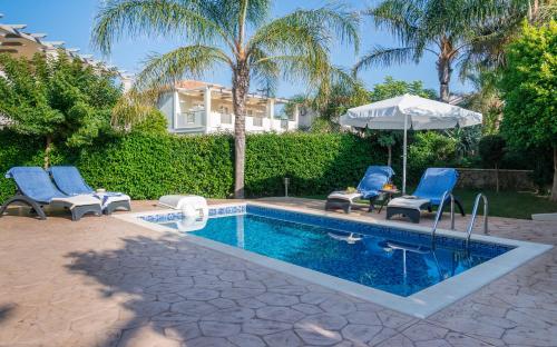 蒂锡利维Mamfredas Luxury Resort的一个带2把蓝色椅子和遮阳伞的游泳池