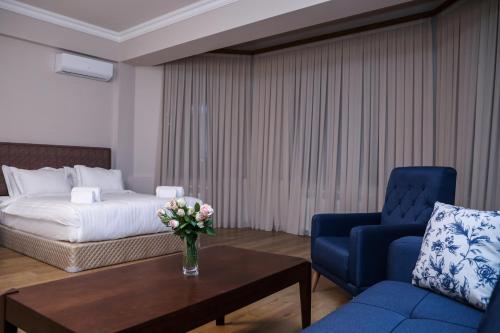埃里温Teryan Pushkin Apart Hotel的酒店客房配有一张床、一张蓝色椅子和一张桌子