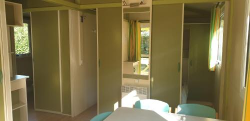罗纳河畔的图尔农Camping Les Foulons的配有桌椅和镜子的客房