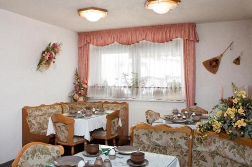 Oschatz膳食之城旅馆的一间带桌椅和窗户的用餐室
