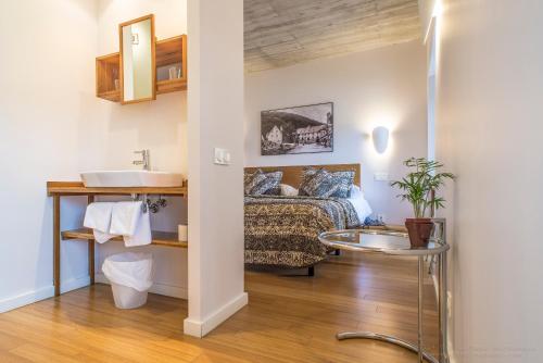 龙塞斯瓦耶斯龙塞斯瓦耶斯酒店的一间带水槽的浴室和一张位于客房内的床