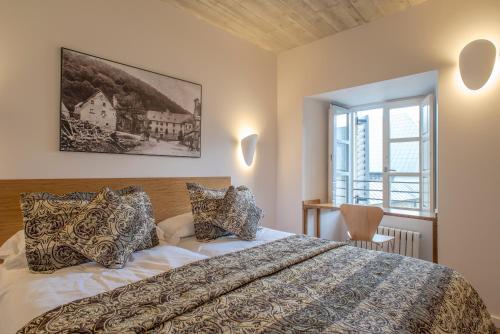 龙塞斯瓦耶斯龙塞斯瓦耶斯酒店的一间卧室设有一张大床和一个窗户。