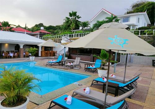 安塞罗亚莱瑞莱克斯酒店及餐厅的游泳池旁设有椅子和遮阳伞